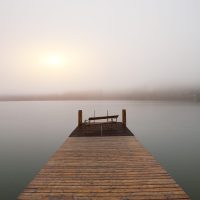 Empty footbridge with a bench on a lake Altausseer at sunrise. Location: resort village Altaussee, Liezen District of Styria, Austria, Alps. Europe.