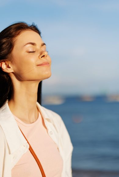 Woman beauty smile with teeth freedom on vacation walks along the beach near the ocean in Bali sunset, happy travel and vacation, sunset light, flying hair, enjoyment of relaxation and harmony. High quality photo