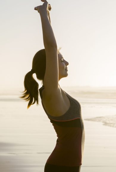 Shoot of a beautiful woman making stretching exercises in the beach