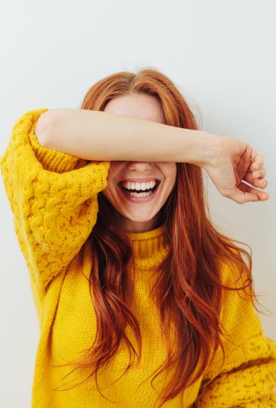 woman covering her eyes with her arm while waiting for a surprise