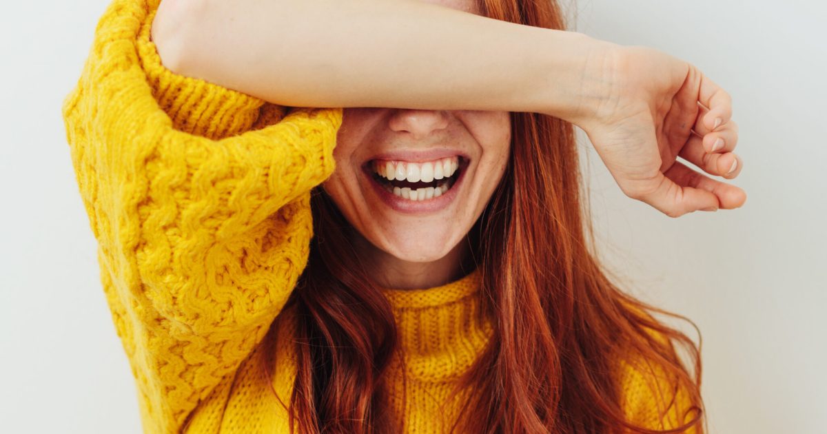 woman covering her eyes with her arm while waiting for a surprise